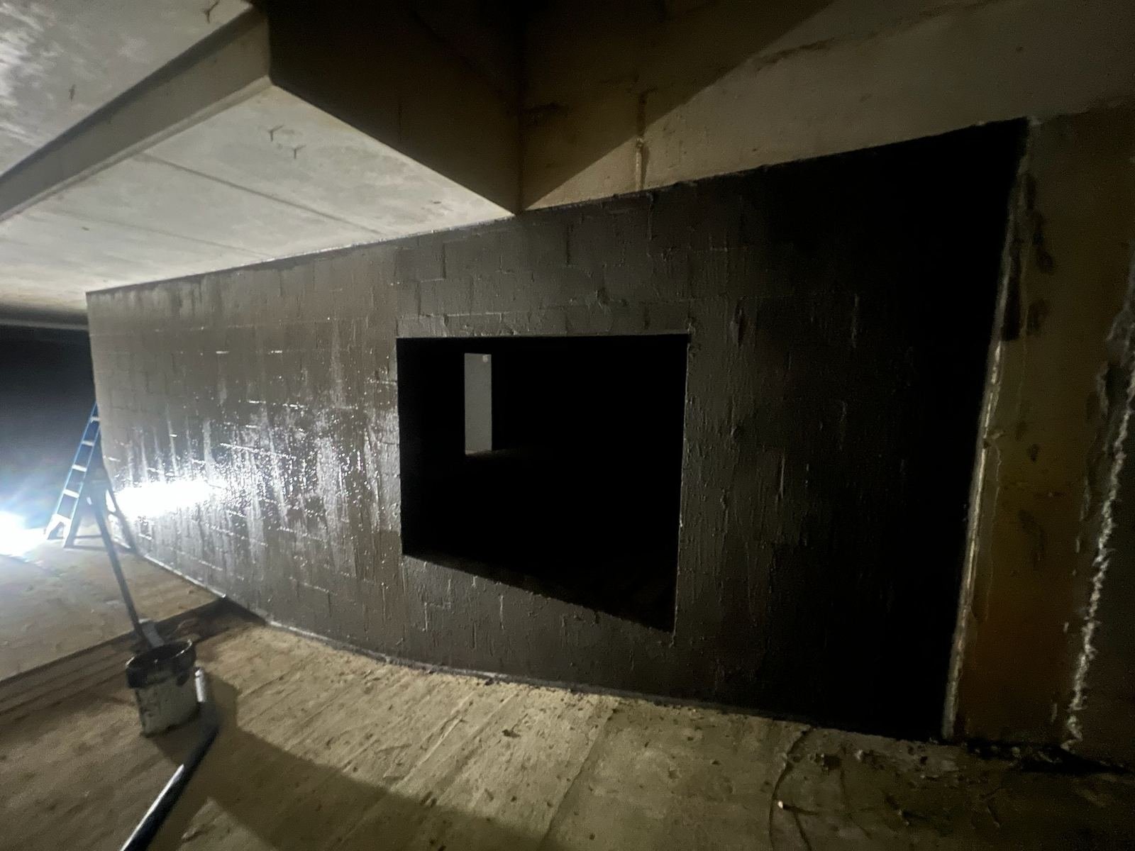 Basement car park waterproofing membrane wrapping around a structural column and service opening