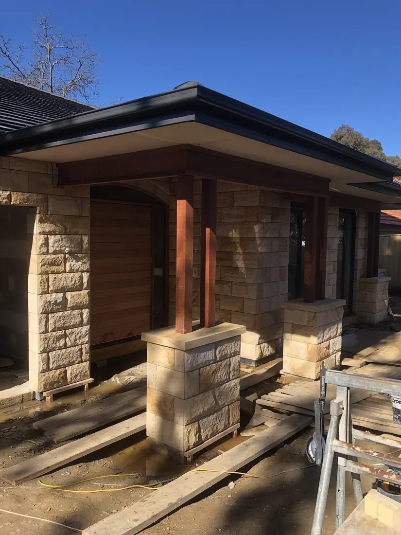 Rock-faced natural stone cladding installed to home facade