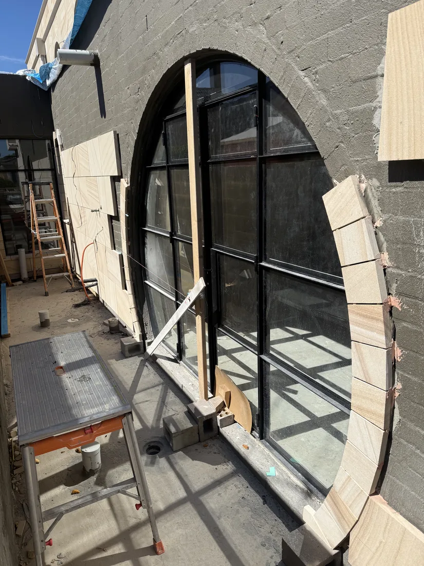 Sandstone surround installed around a feature arched window