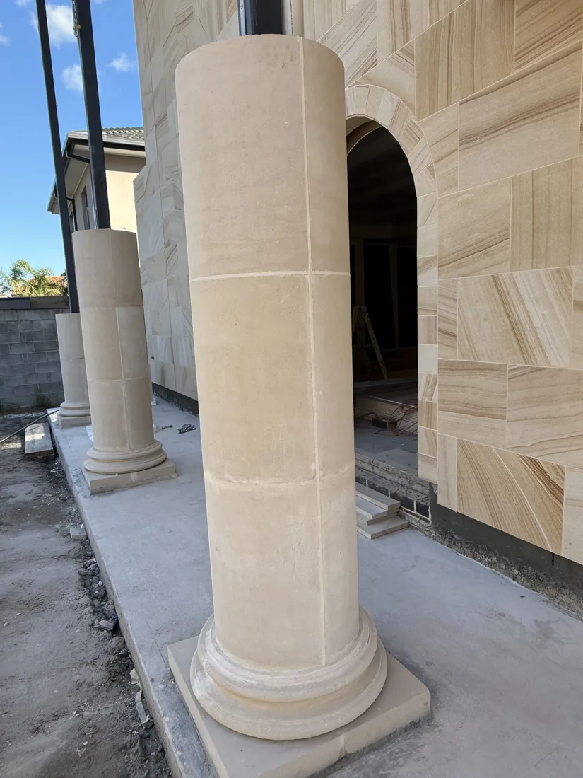 Sandstone column with a decorative base at the entrance