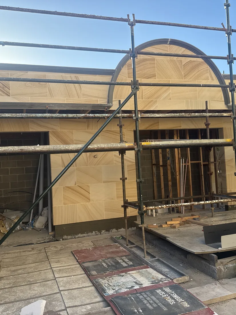 Sandstone arched pediment detail above a side entrance