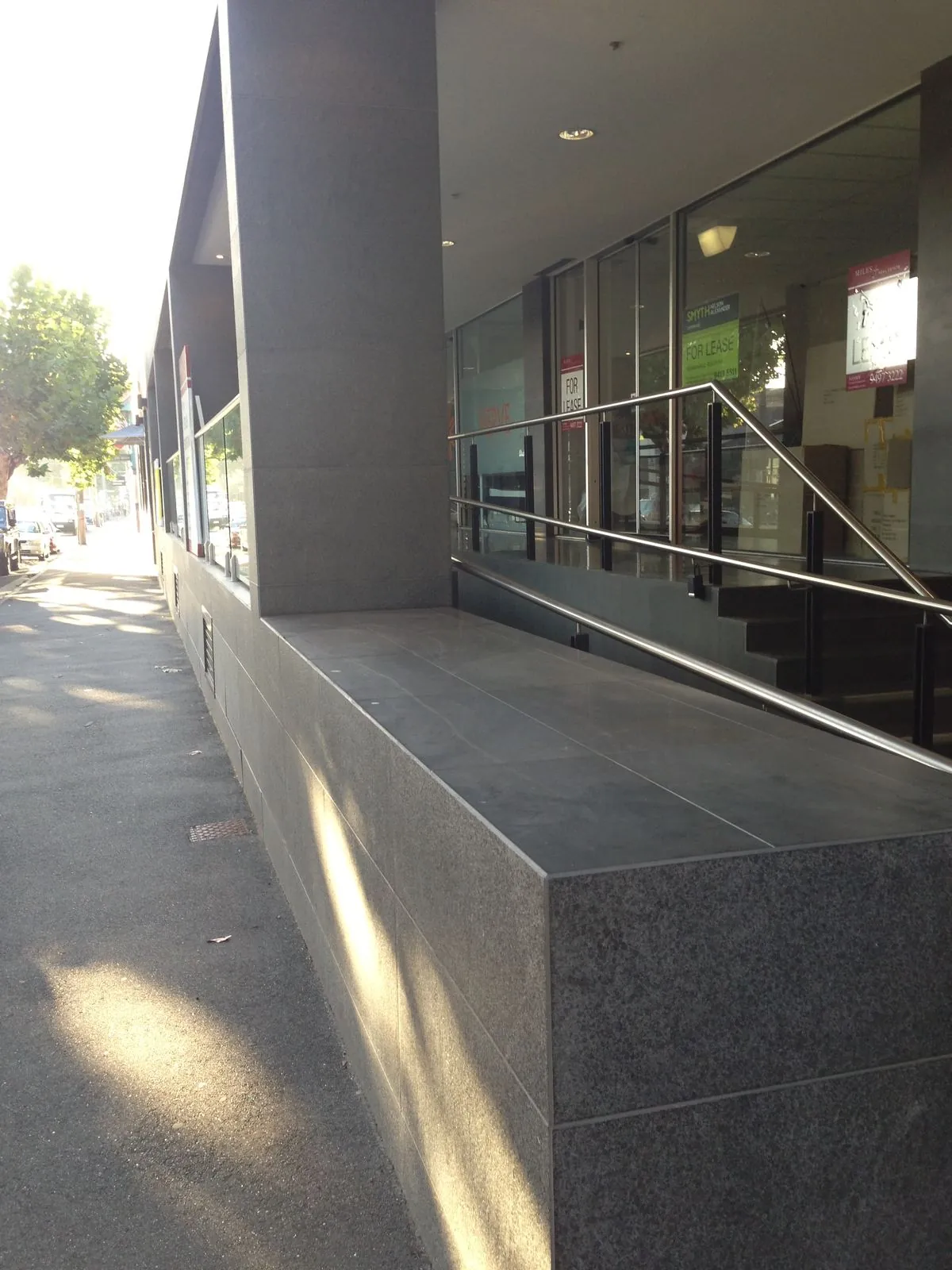 Granite-clad corner column with bluestone bench seating along the exterior walkway