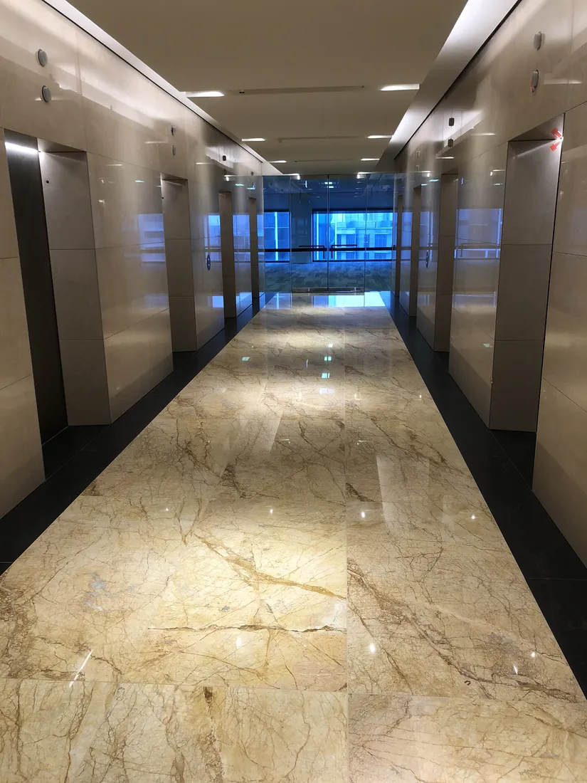 Finished Crema Marfil marble lift lobby floor with black granite borders at Collins Place Melbourne
