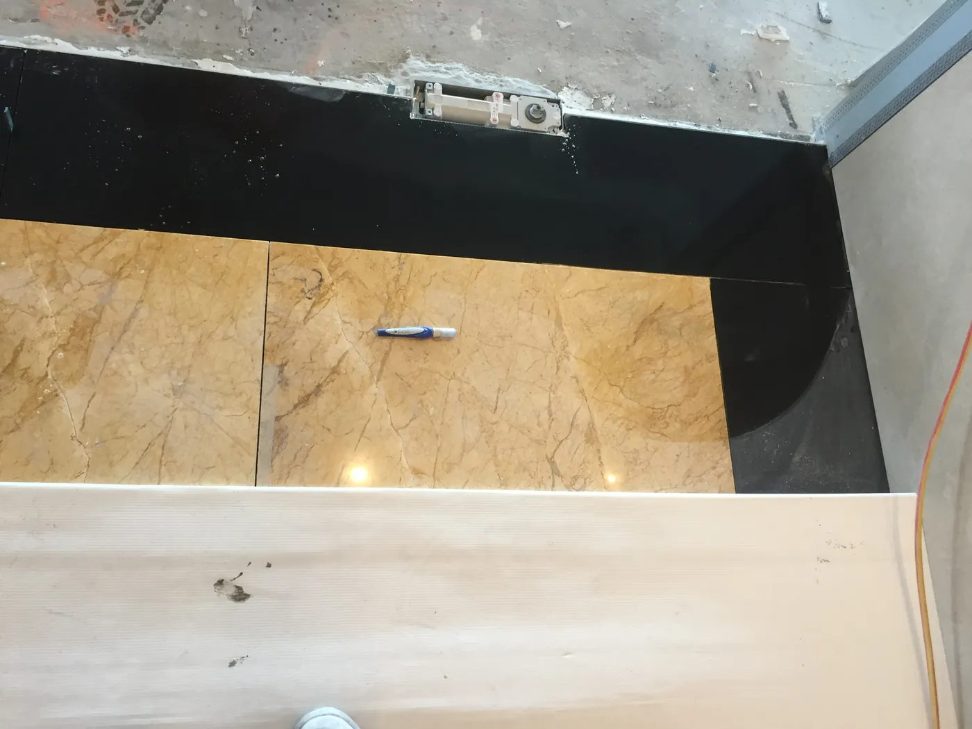 Crema Marfil marble floor and black granite border detailing at Collins Place