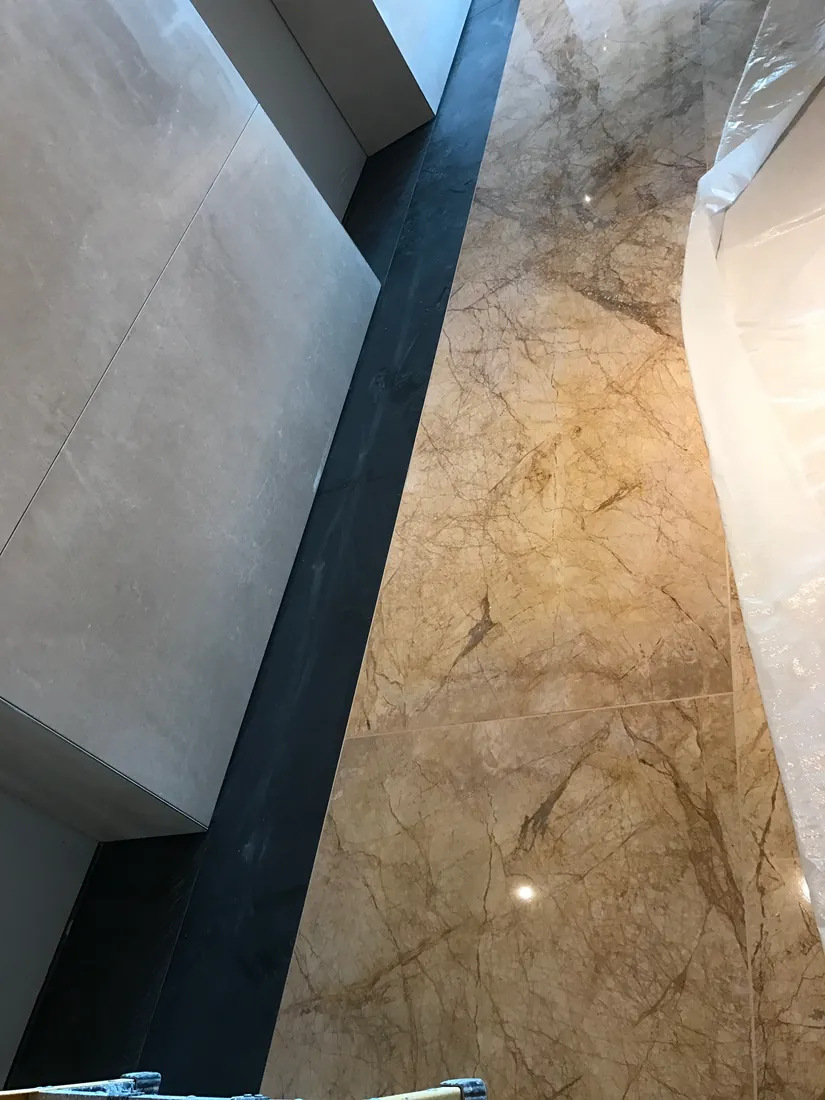 Premium Collins Place lobby finish with Crema Marfil marble and black granite borders