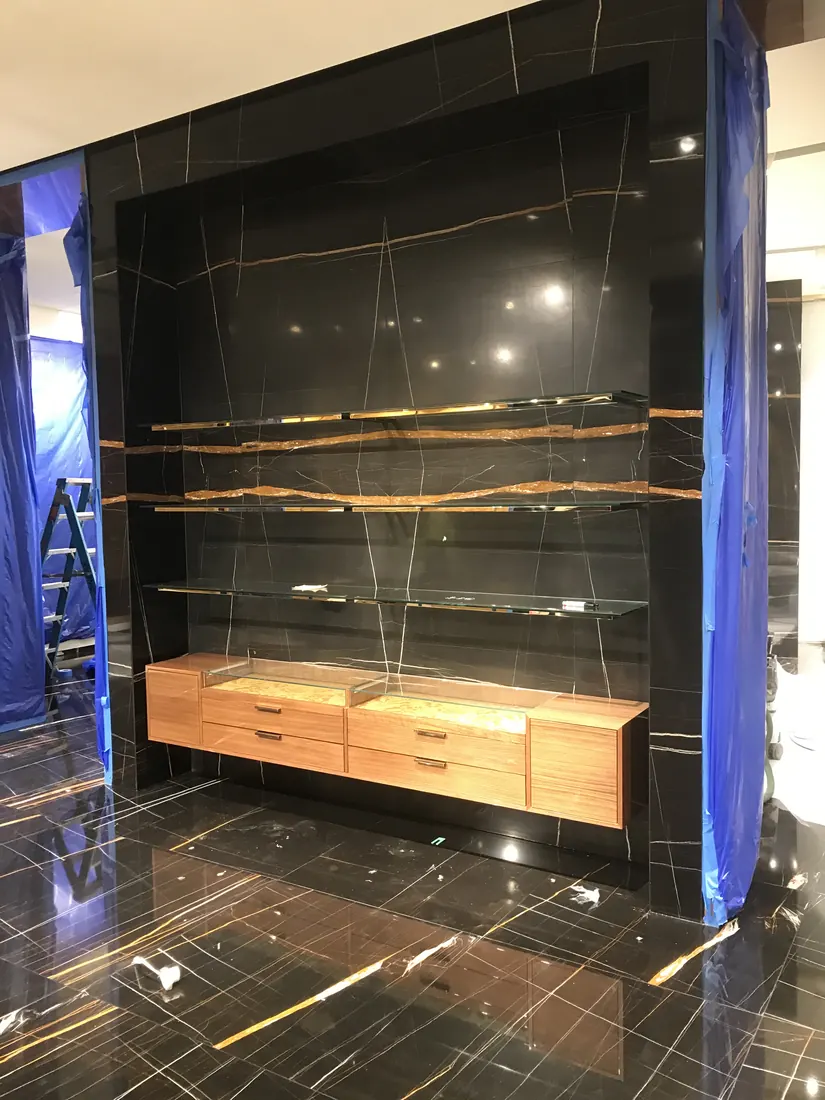 Finished black marble display wall with glass shelving for boutique fit-out