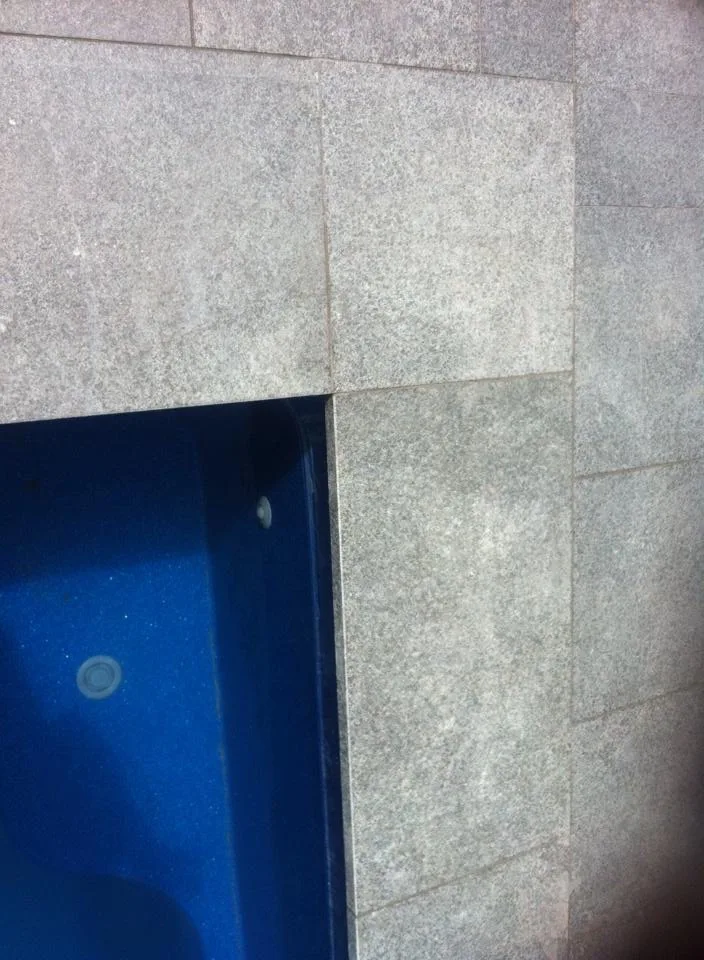 Clean mitred granite coping corner detail on residential pool in Hillside