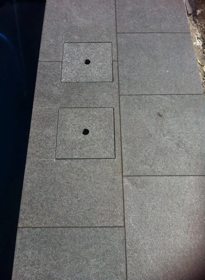Precision-cut granite skimmer box cover on pool coping installation