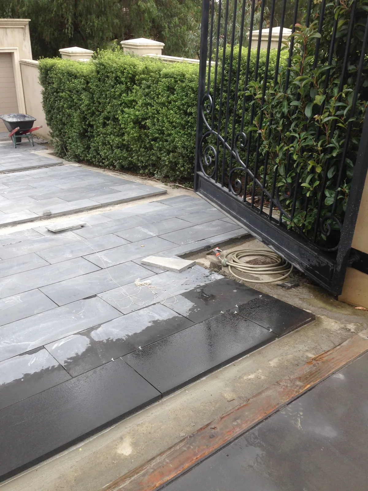 Bluestone driveway paving installed alongside the entry gate