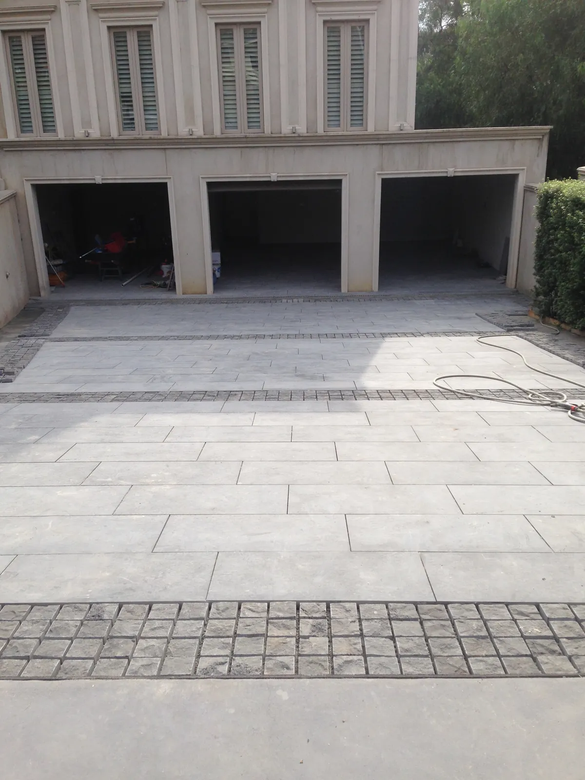 Bluestone driveway paving with cobblestone border installed in front of a triple garage in Keilor, Victoria
