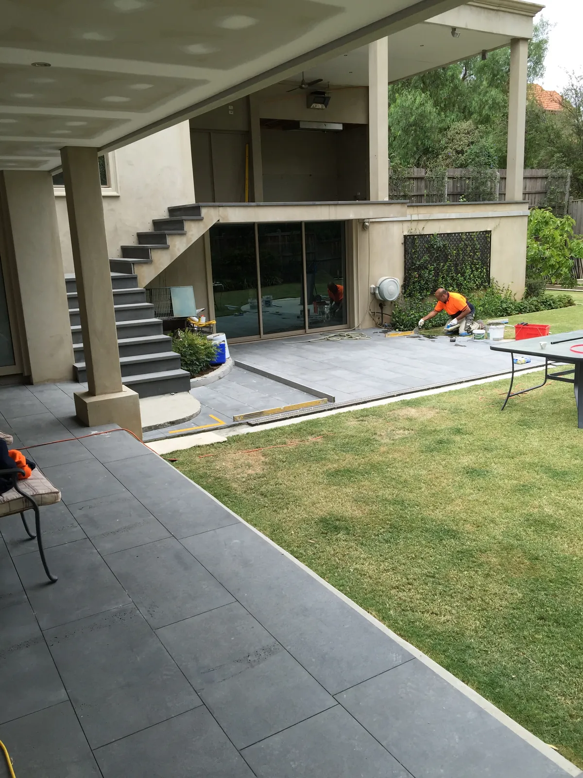 TN Stone tradesmen completing bluestone paving to the rear patio