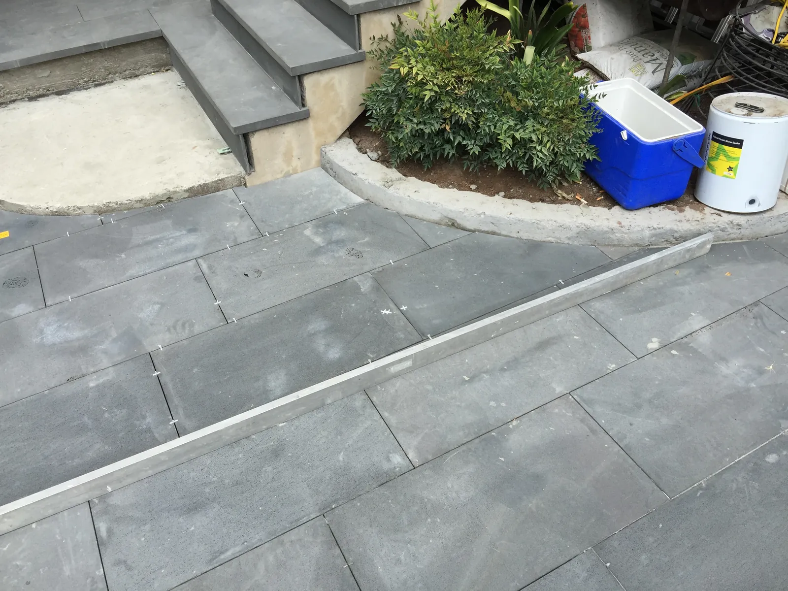 Bluestone paving detail with aluminium edge trim near the garden bed