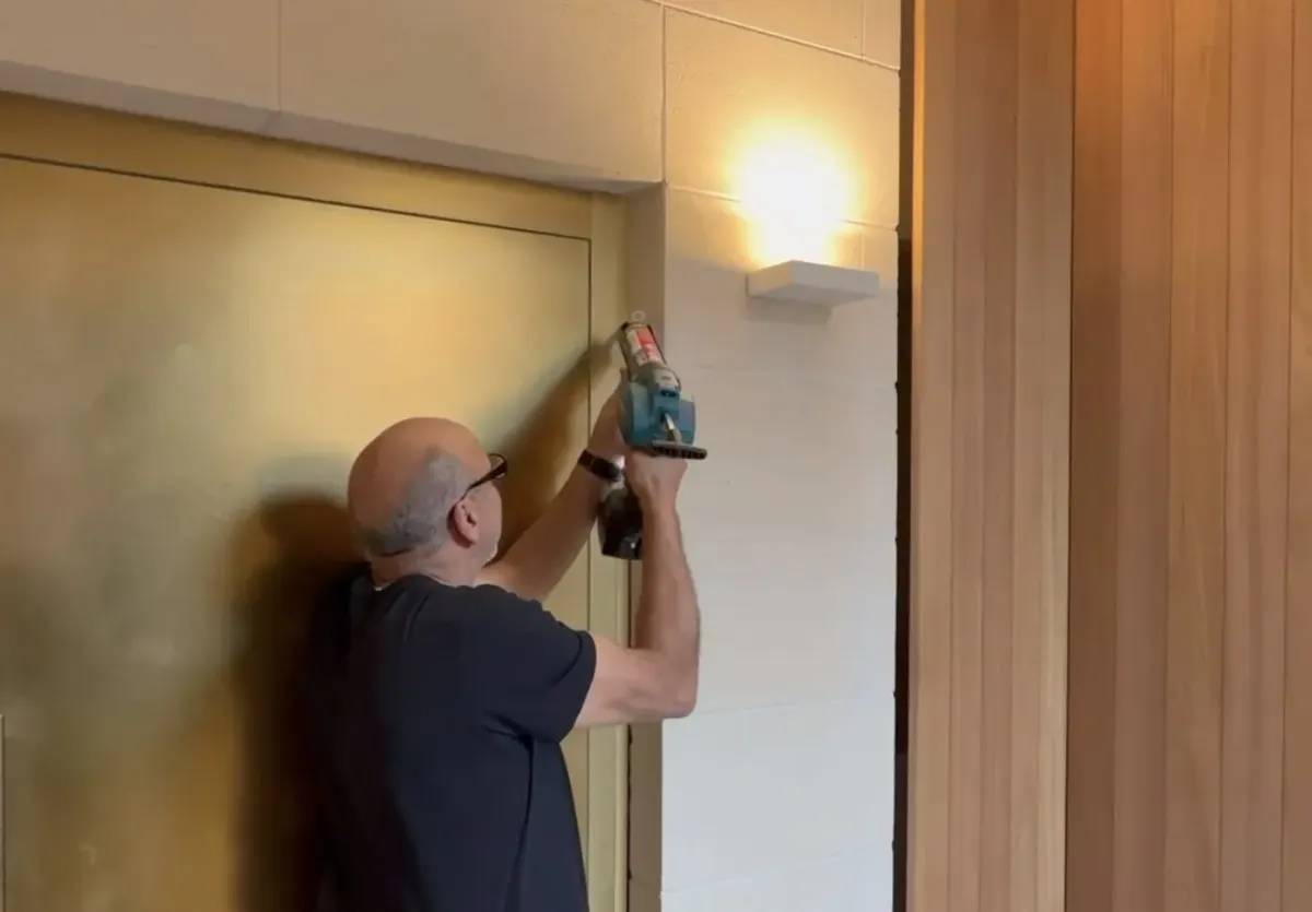TN Stone applying silicone caulking to a door frame junction in Toorak
