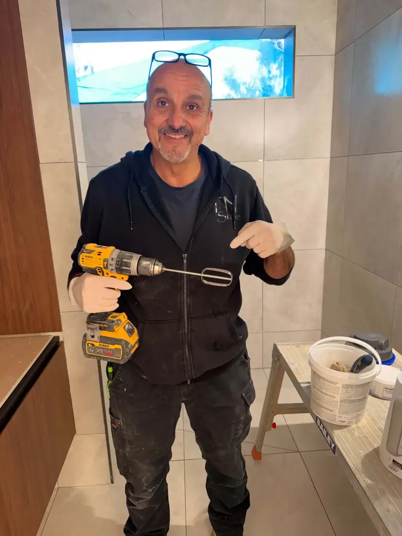 Mixing epoxy grout on site with a drill and paddle mixer