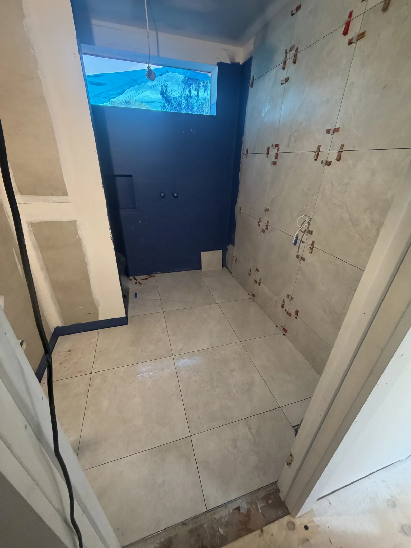 Large-format porcelain shower wall and floor, a low-maintenance alternative to marble