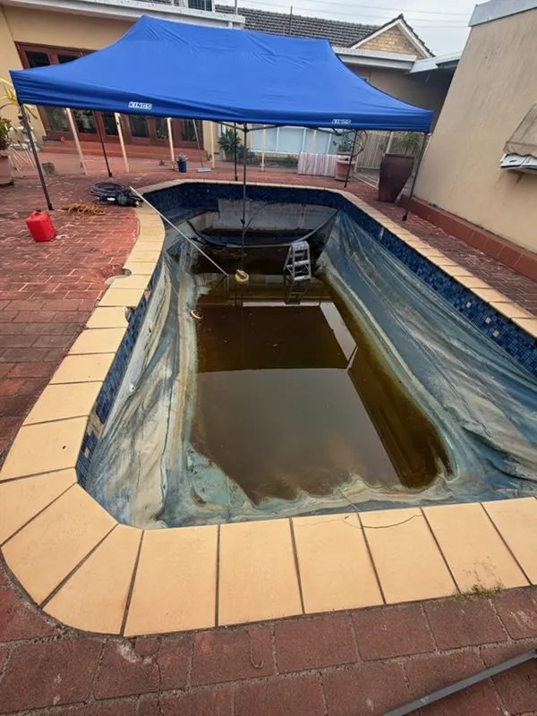 Neglected Moorabbin swimming pool full of stagnant discoloured water before restoration
