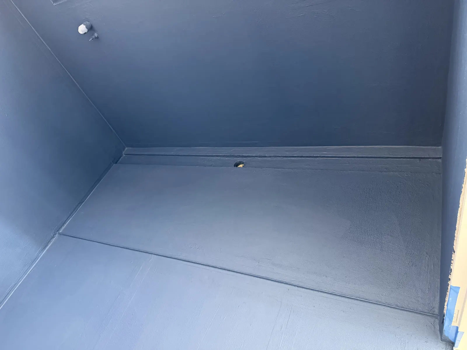 Waterproofing membrane applied to floor and wall junction in a bathroom renovation
