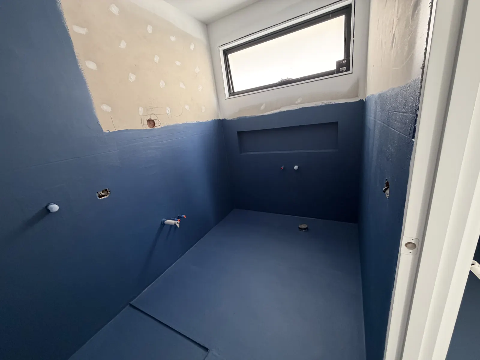 Waterproofing membrane applied around a shower niche and window frame