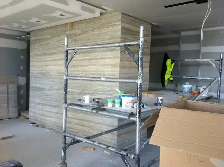Scaffold setup during travertine slab installation in South Yarra apartment